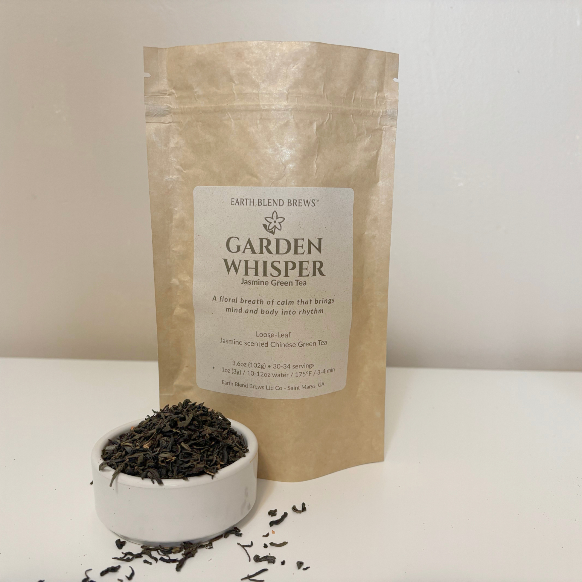 Tea packaging labeled 'Garden Whisper' with loose tea leaves in a bowl on a white background